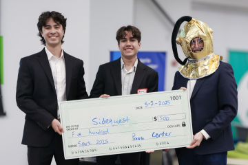 A trio hold a large check