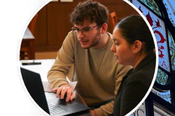Photograph of two students discussing over a laptop