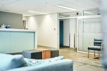 Empty medical waiting room with reception desk and chairs in clean and well-lit clinic lobby