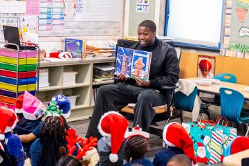 Roquan Smith of the Baltimore Ravens reads with Henderson-Hopkins students in December 2025.