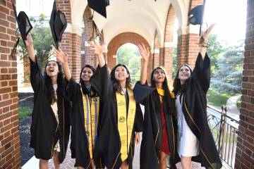 Students in regalia pose for a photo