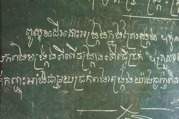 A chalkboard is covered with a script language 