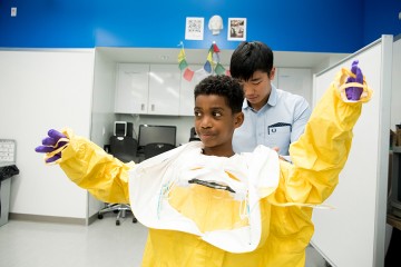 A student puts on the Ebola Suit