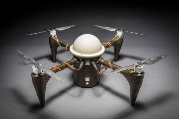 Small drone with white, domed center and four propellors