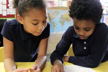 Two children collaborate on a project