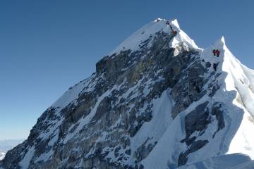Climbers climb a mountain ridge over Everest