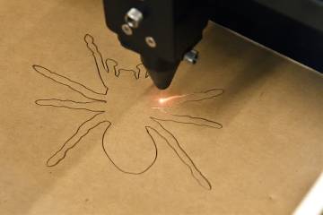 Laser cutter carves out a spider at the Hopkins Makerspace