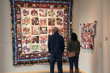A couple looks at a quilt display