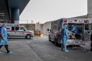 Medical personnel screen a patient in an ambulance