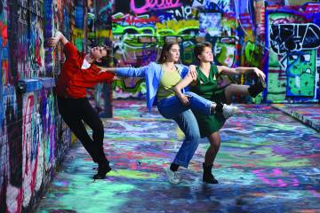 Dancers in a colorful graffitied room
