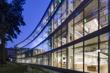 The image shows UTL's curved glass facade and the lab spaces inside
