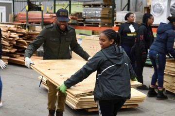 Students carry plywood boards