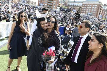 A family hugs their student during Commencement