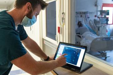 Jonathan Cope, respiratory therapy staff, uses a robotic system to remotely control ventilators 