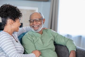 Adult daughter conversing affectionately with smiling father