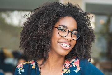 Smiling woman with braces and eyeglasses