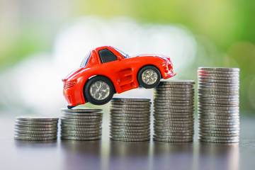 Toy car riding over stacks of coins