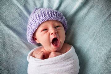 Newborn baby swaddled in blanket