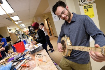 A student holds his banjo in the playing position