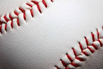 A closeup of distinctive red stitching on a white leather baseball