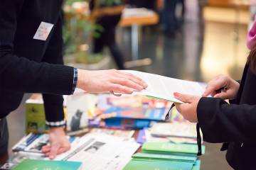 Man and woman sharing information leaflet over exhibition stand