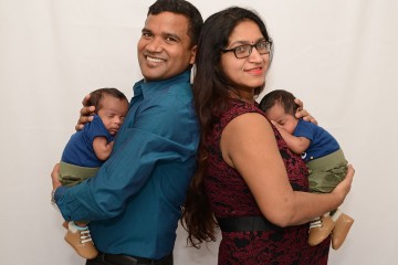 Couple poses back to back for photo with their twin infants