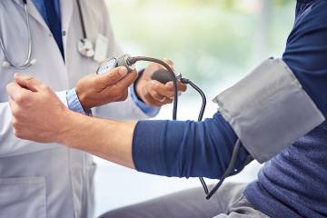 Doctor taking a man's blood pressure reading