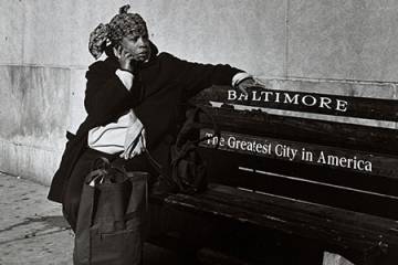 A woman sits on a bench in Baltimore