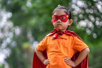 Young girl playing in superhero costume
