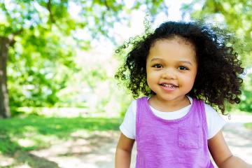 Cute little girl walking in the park on a sunny day