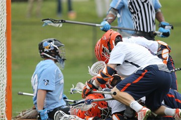 Virginia players celebrate winning goal in front of JHU's goalkeeper