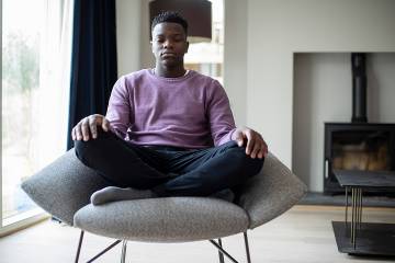 Man practicing chair yoga in his home