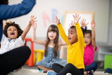 Lively preschoolers interacting with their teacher