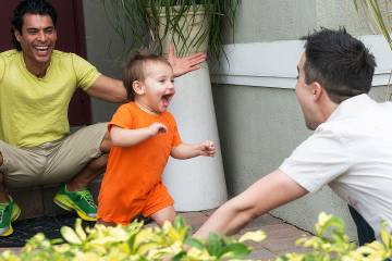 Toddler playing with his two fathers