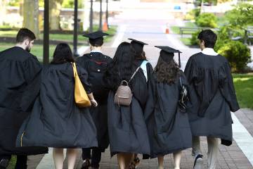 Student walk away from the camera wearing Commencement regalia