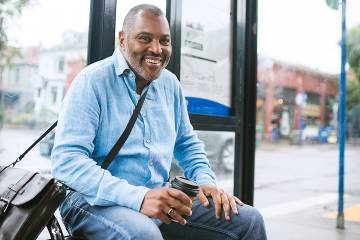 Middle-aged man sitting at a bus stop