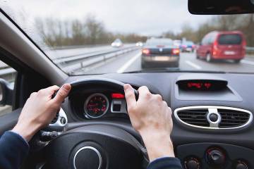 Closeup of a driver’s hands on steering wheel while commuting to work