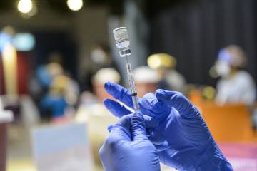 A healthcare worker readies a COVID-19 vaccine at a vaccine clinic operated by Johns Hopkins at Port Discovery in February 2022