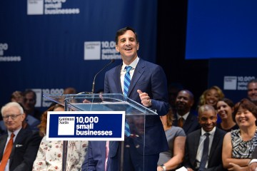 President Ronald J. Daniels at podium adorned by 10,000 Small Businesses sign