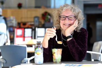 Donna Rowley eating a fruit cup with a bottle of diet iced tea on the table