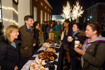 Students line up to pick donuts from trays on a table