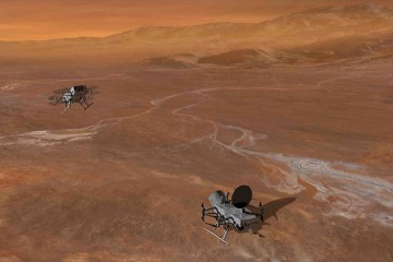 Two drone devices with multiple rotors fly across a brown, rocky, barren surface, representing the surface of Titan