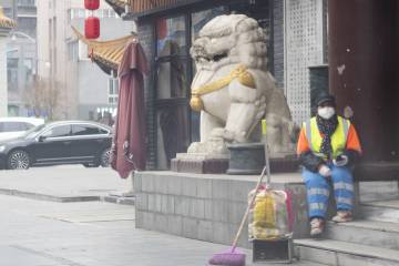 Chinese sanitation worker rests on roadside