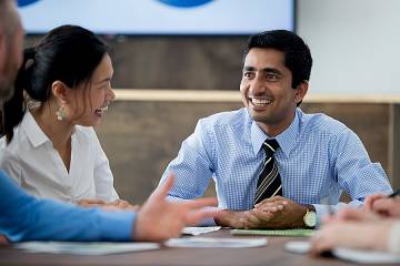 Confident-looking man talking with team members