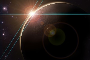 Image shows a ray of light silhouetting a planet in outer space