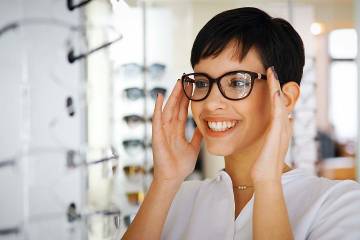 Smiling woman trying on eyeglasses in a store