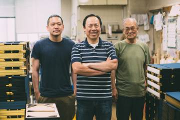 Three generations of craftsmen stand in their workshop