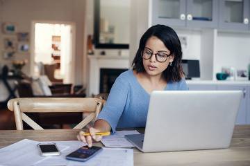 Woman working on her budget at her dining table