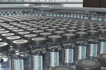 Vials of flu vaccine on a factory conveyer belt