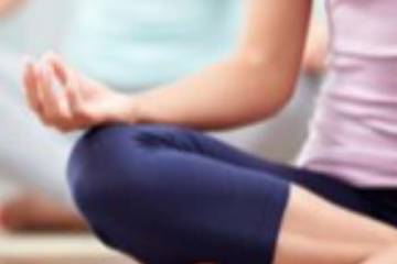Close-up, cropped image of someone sitting in a yoga pose